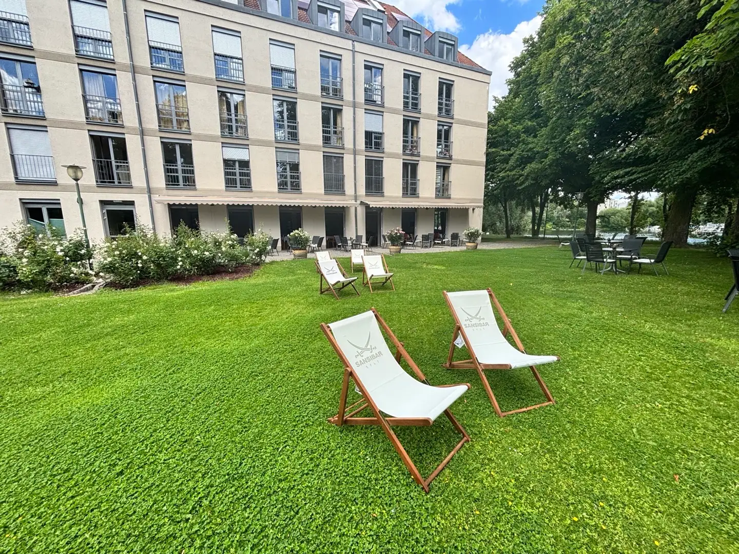 Liegestühle auf der großen grünen Wiese vor der Terrasse des ResidenzCafés.